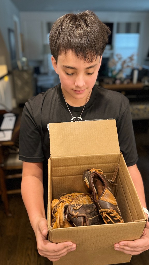 Jacob holding a box of baseball gloves